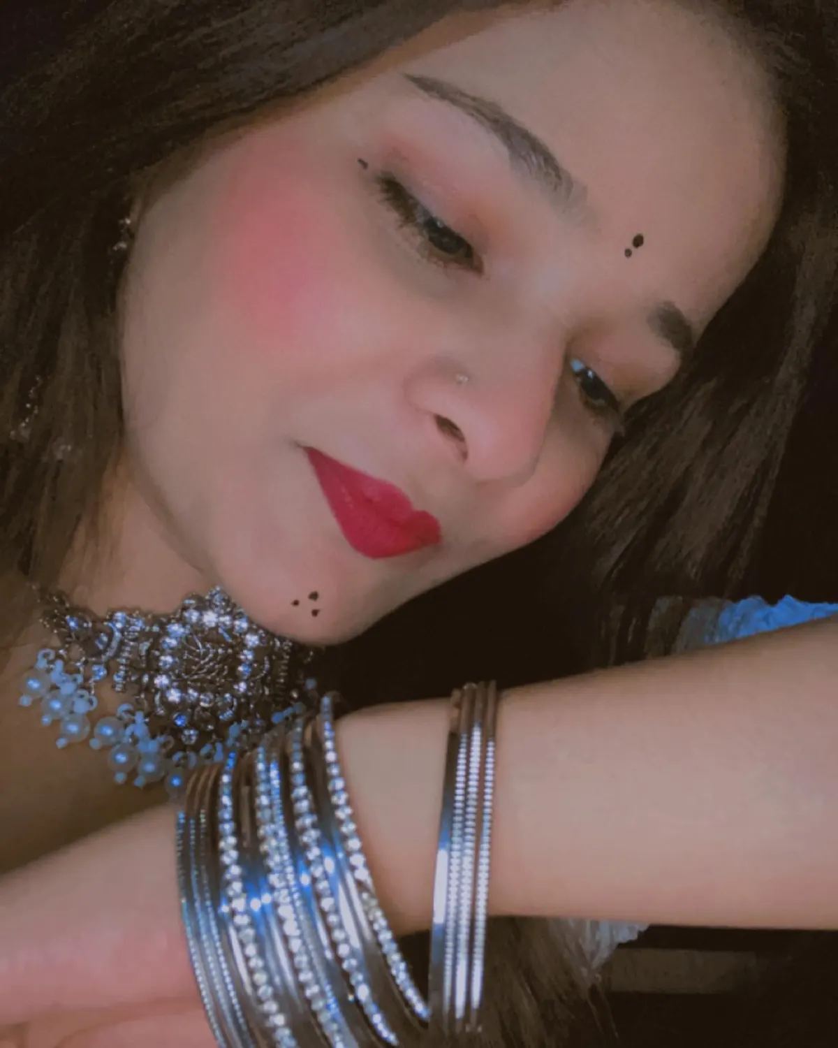 Nitya Shukla smiling, resting her head on her arm